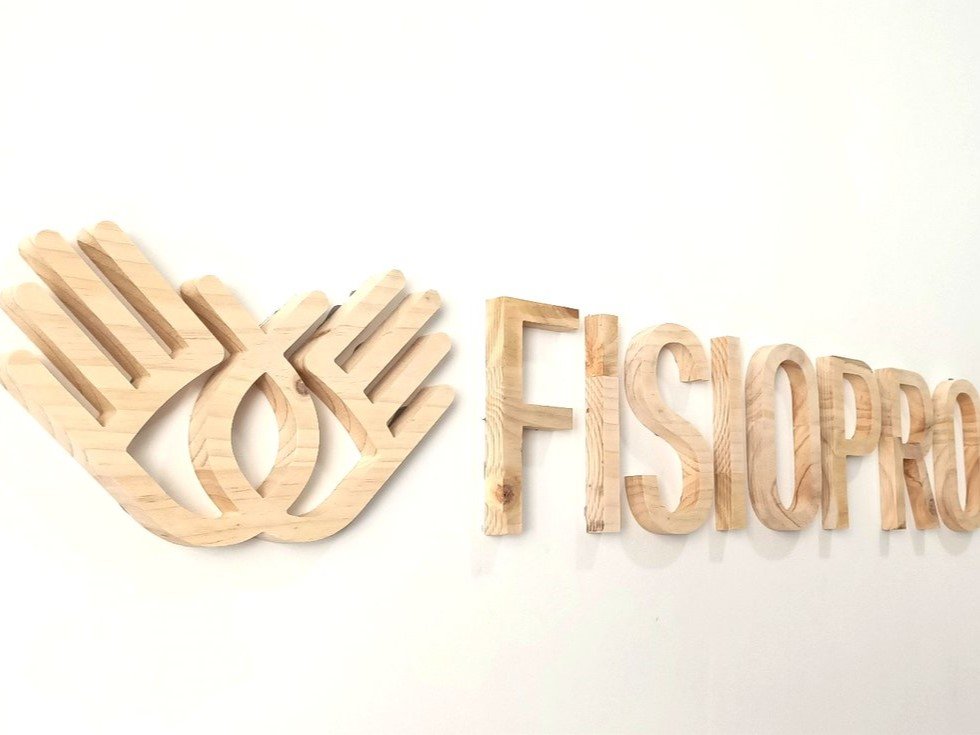 Letras recortadas en madera natural instaladas en interior.
